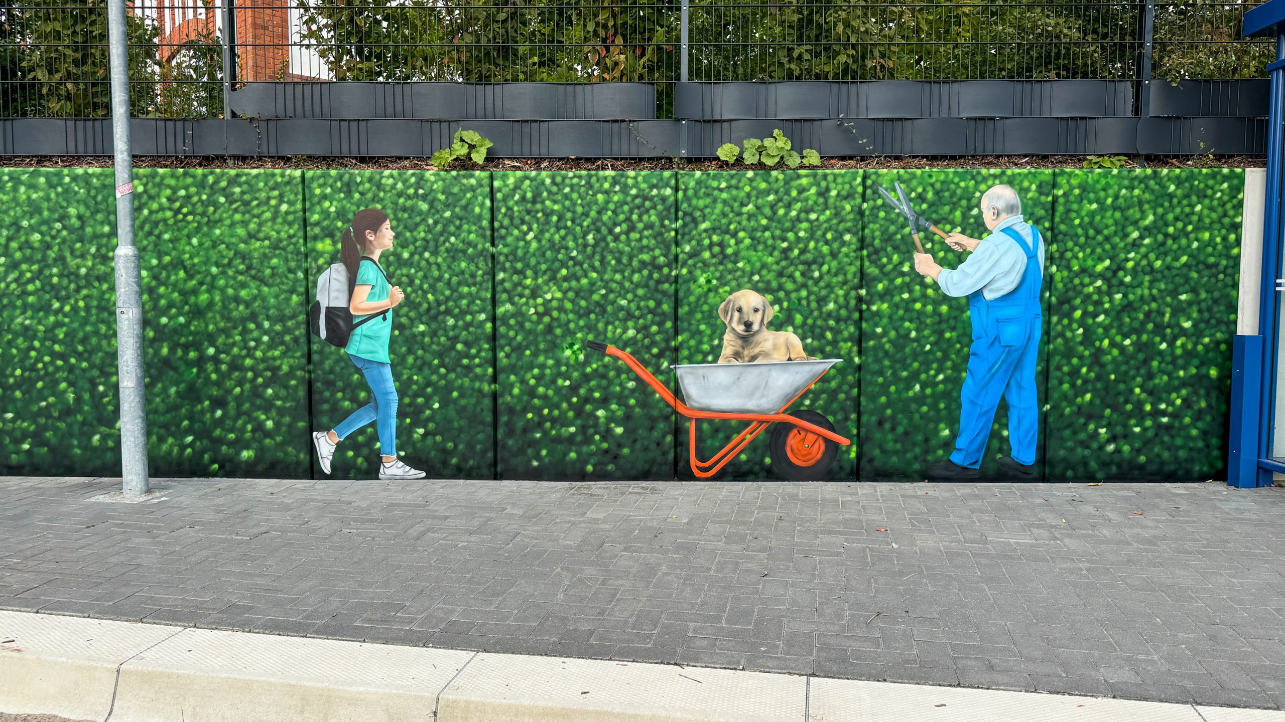 Illusionsmalerei mit Graffiti – grüne Hecke als Wandkunst am Bahnhof Sörup