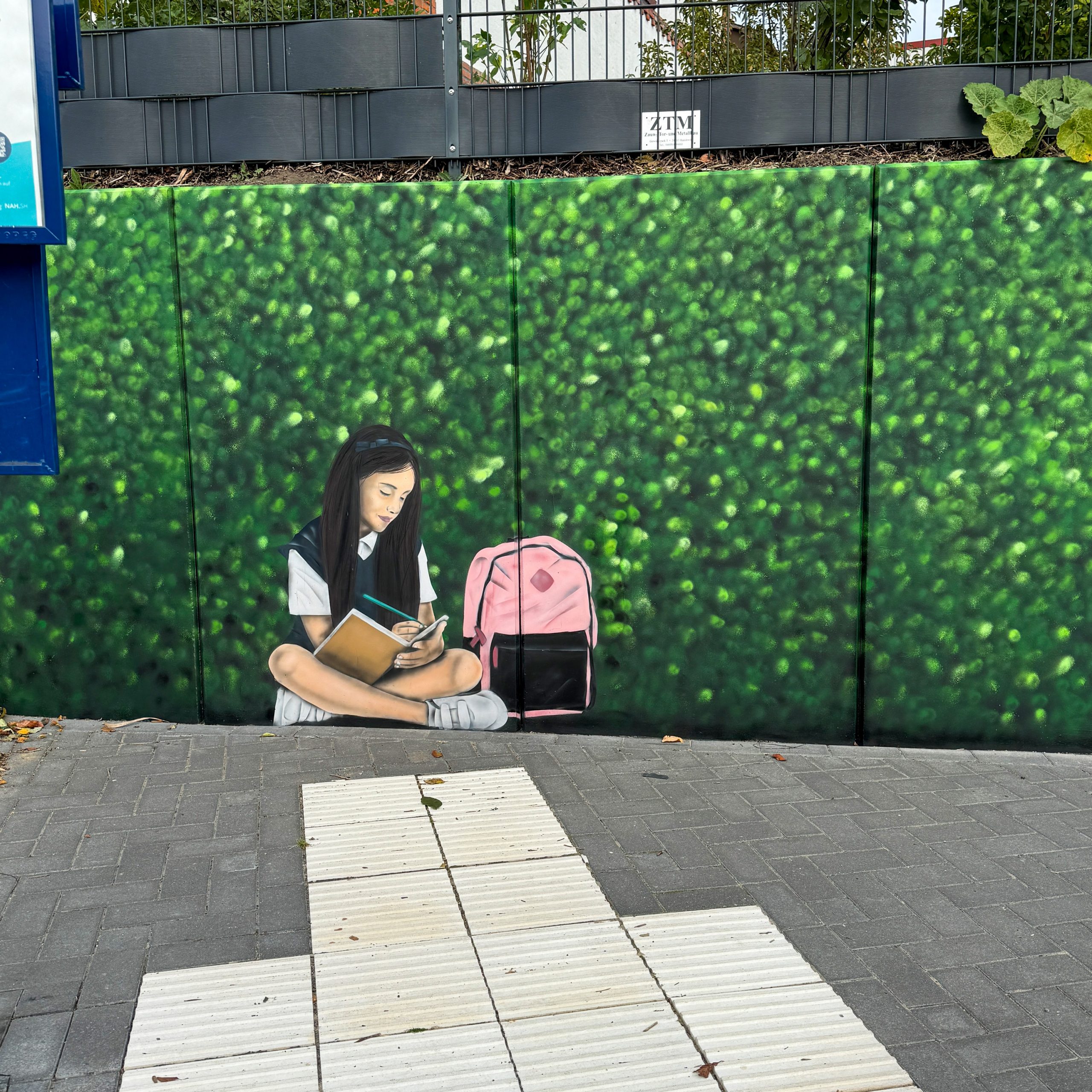 Illusionsmalerei mit Graffiti – grüne Hecke als Wandkunst am Bahnhof Sörup