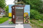 Wikinger Graffiti auf einem Beton-WC in Schleswig mit Rapsfeld und Comic-Motiven