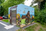 Wikinger Graffiti auf einem Beton-WC in Schleswig mit Rapsfeld und Comic-Motiven