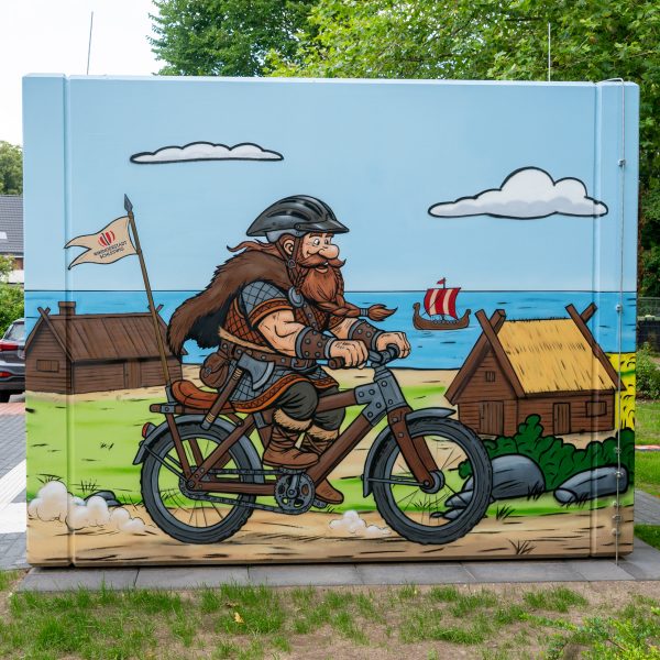 Wikinger Graffiti auf einem Beton-WC in Schleswig mit Rapsfeld und Comic-Motiven