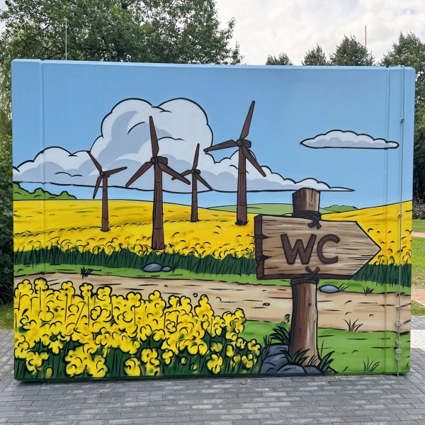 Wikinger Graffiti auf einem Beton-WC in Schleswig mit Rapsfeld und Comic-Motiven