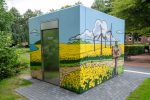 Wikinger Graffiti auf einem Beton-WC in Schleswig mit Rapsfeld und Comic-Motiven